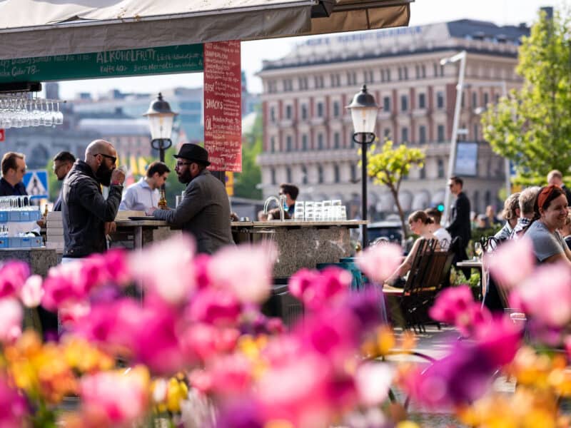 Uteservering vid Lydmar Hotel i Stockholm med utsikt mot vattnet – somrig atmosfär med stadens silhuett i bakgrunden.