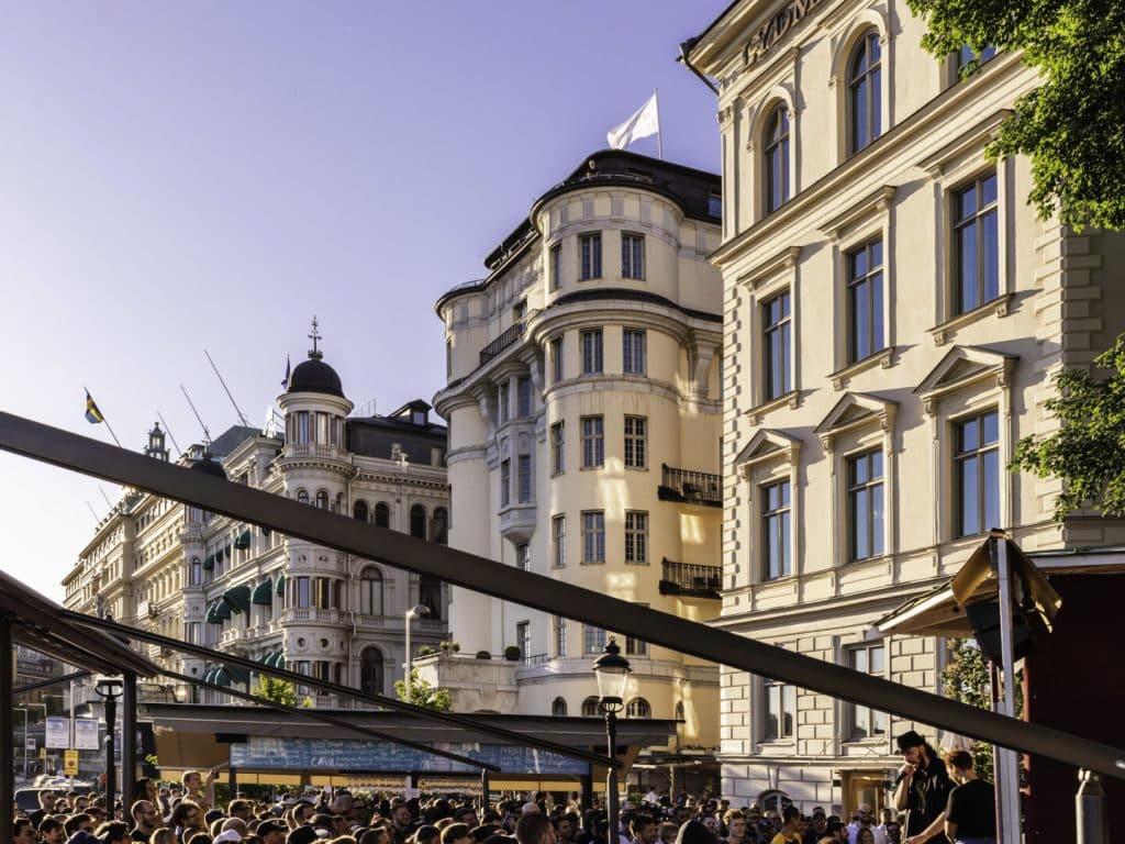 Uteservering vid Lydmar Hotel i Stockholm med pulserande stadsliv och historiska byggnader.