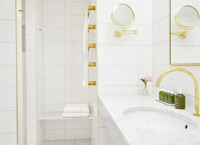 Hotel Diplomat Stockholm. Badrummen, med eleganta gulddetaljer, bidrar till känslan av diskret lyx.