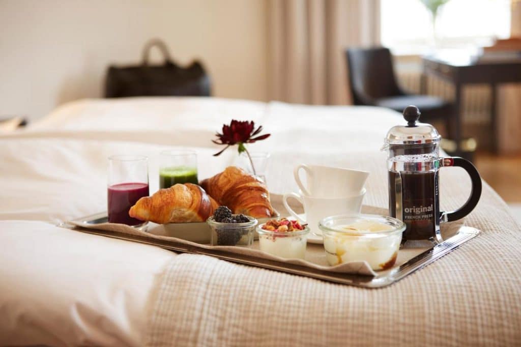 Frukost serverad på rummet på Hotel Diplomat i Stockholm med färska bakverk och nybryggt kaffe.
