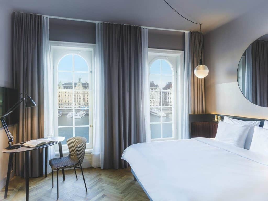 Exklusivt sovrum på Strand Hotel i Stockholm med modern design, mjuka textilier och lugn atmosfär.