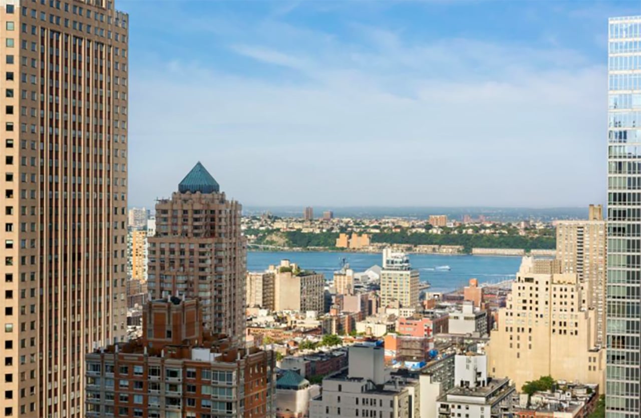 New York Citys skyline med ikoniska skyskrapor, stadsliv i rörelse och silhuetten av Manhattan i bakgrunden.