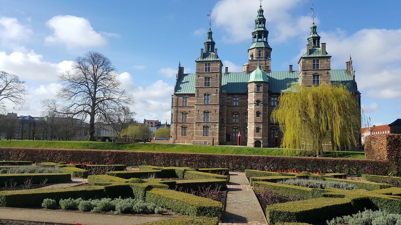 Utsikt över Rosenborgs slott i Köpenhamn omgivet av grönskande trädgårdar, historisk renässansarkitektur och en stillsam parkmiljö.