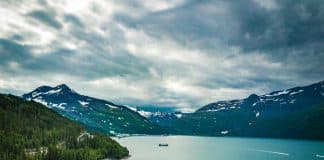 Spektakulär fjord i Alaska med turkost vatten, skogklädda berg och dramatiskt landskap