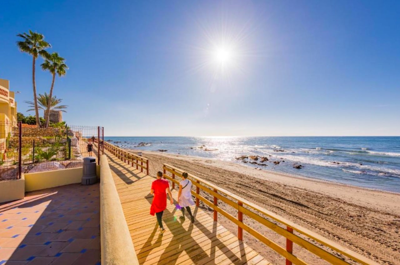 Strandpromenaden i La Cala de Mijas på Costa del Sol med restauranger och palmträd