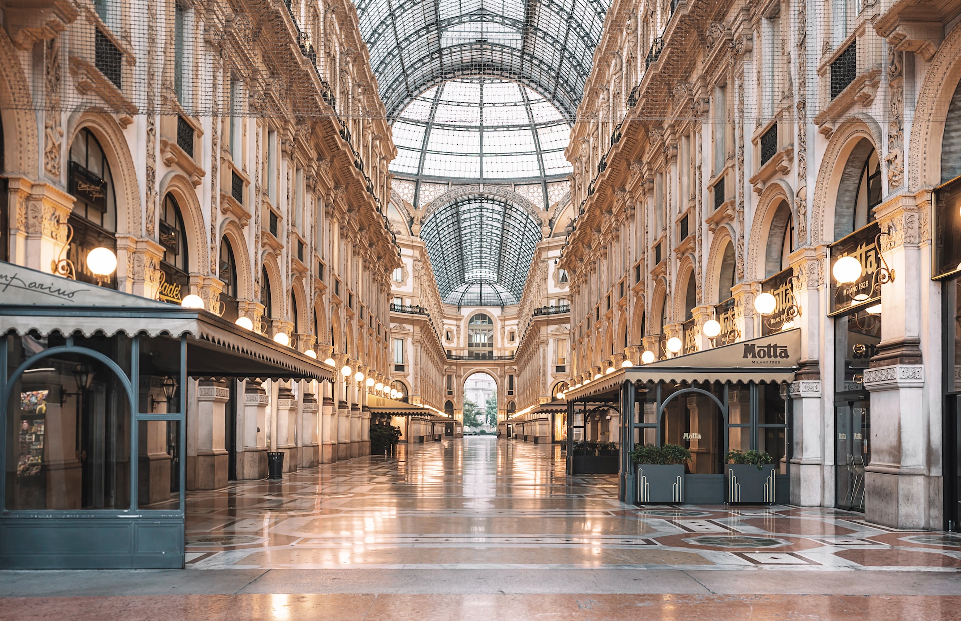 Interiøret i Galleria Vittorio Emanuele II i Milano, med sin ikoniska glaskupol, praktfulla arkitektur och exklusiva butiker i historisk miljö.