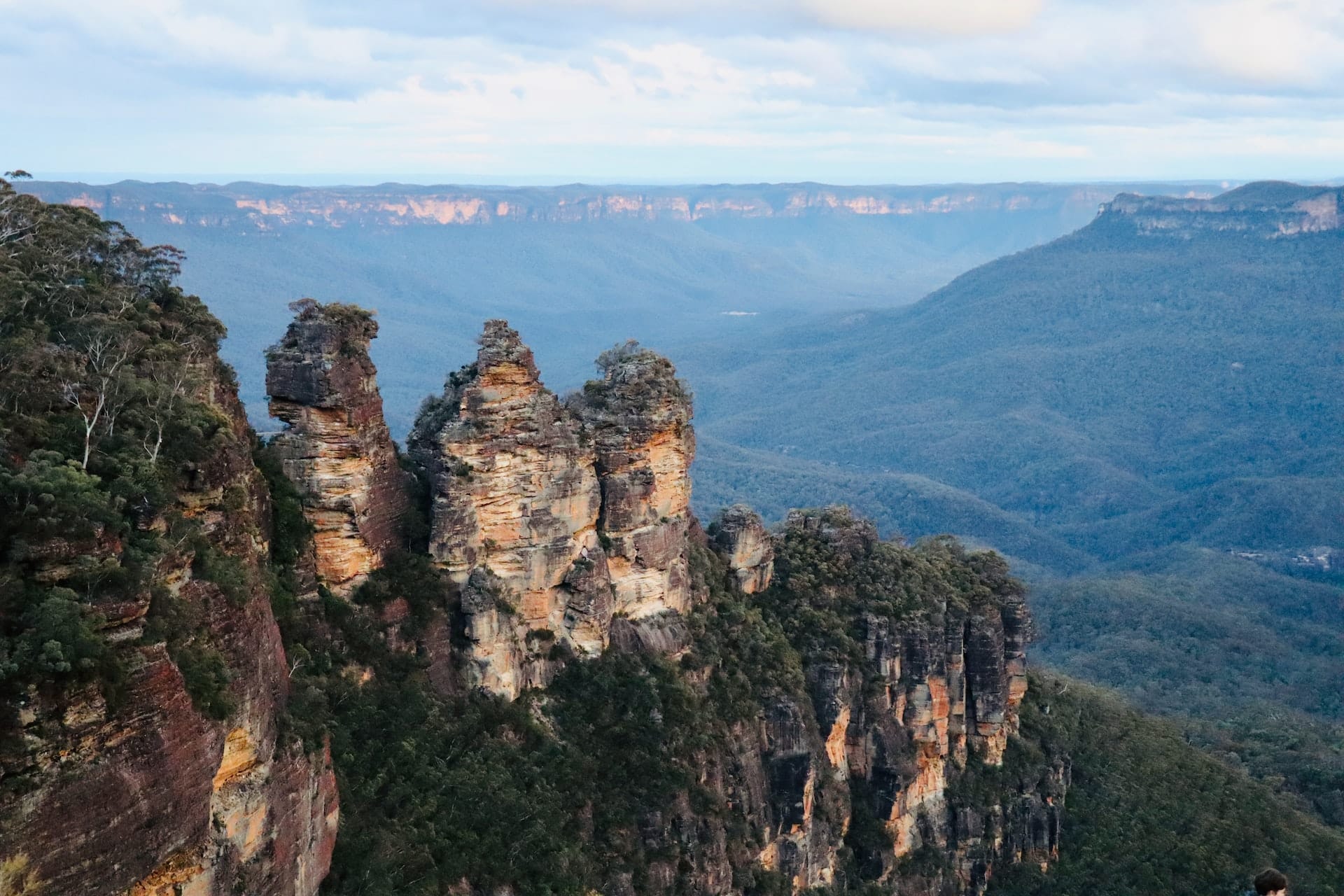 De ikoniska klippformationerna Three Sisters i Blue Mountains nationalpark nära Sydney, med vidsträckt utsikt över dalar och eukalyptusskog.
