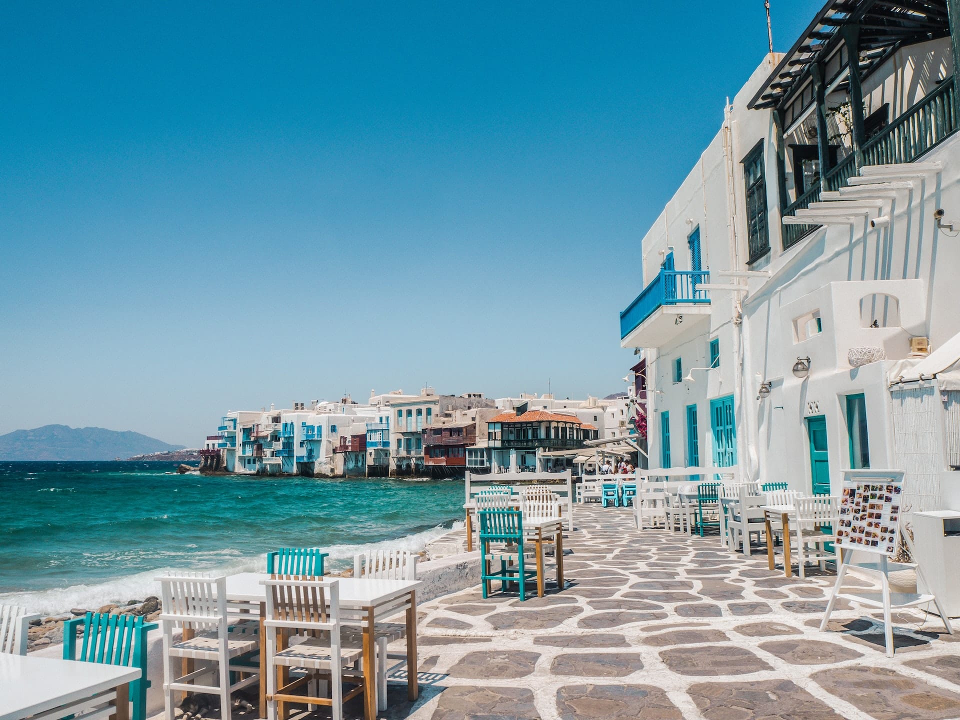 Strand och vitkalkade hus på Mykonos i Grekland