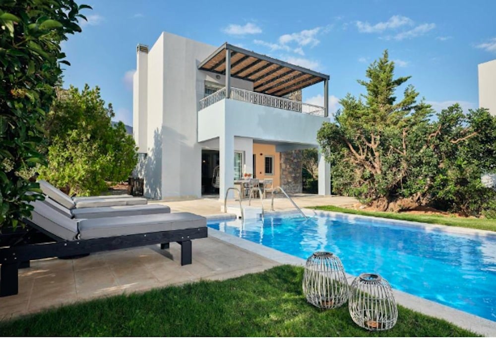 Modern villa med privat pool, stilren arkitektur och grönskande omgivningar – ett exklusivt boende för total avkoppling på Kreta.