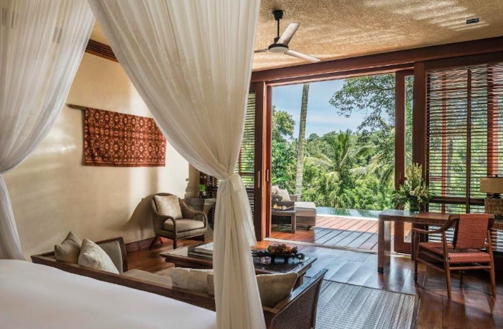 Lyxigt resort på Bali omgivet av frodig djungel, med elegant arkitektur, infinitypool och utsikt över Ayungfloden.