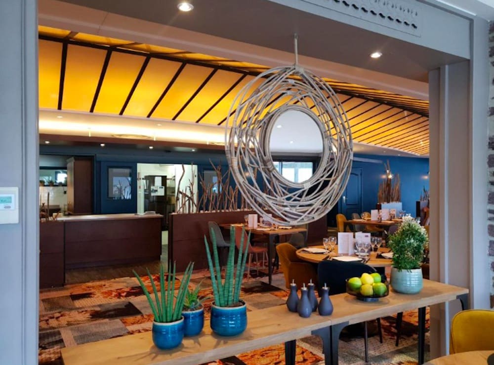 Kafé och restaurang med mysig atmosfär, elegant dukning och utsikt över omgivningarna nära Mont-Saint-Michel.