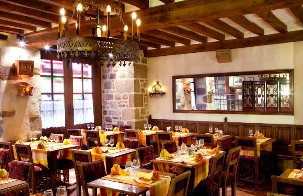 Charmig restaurang på Mont-Saint-Michel med traditionell inredning, kullerstensgata utanför och historisk atmosfär.