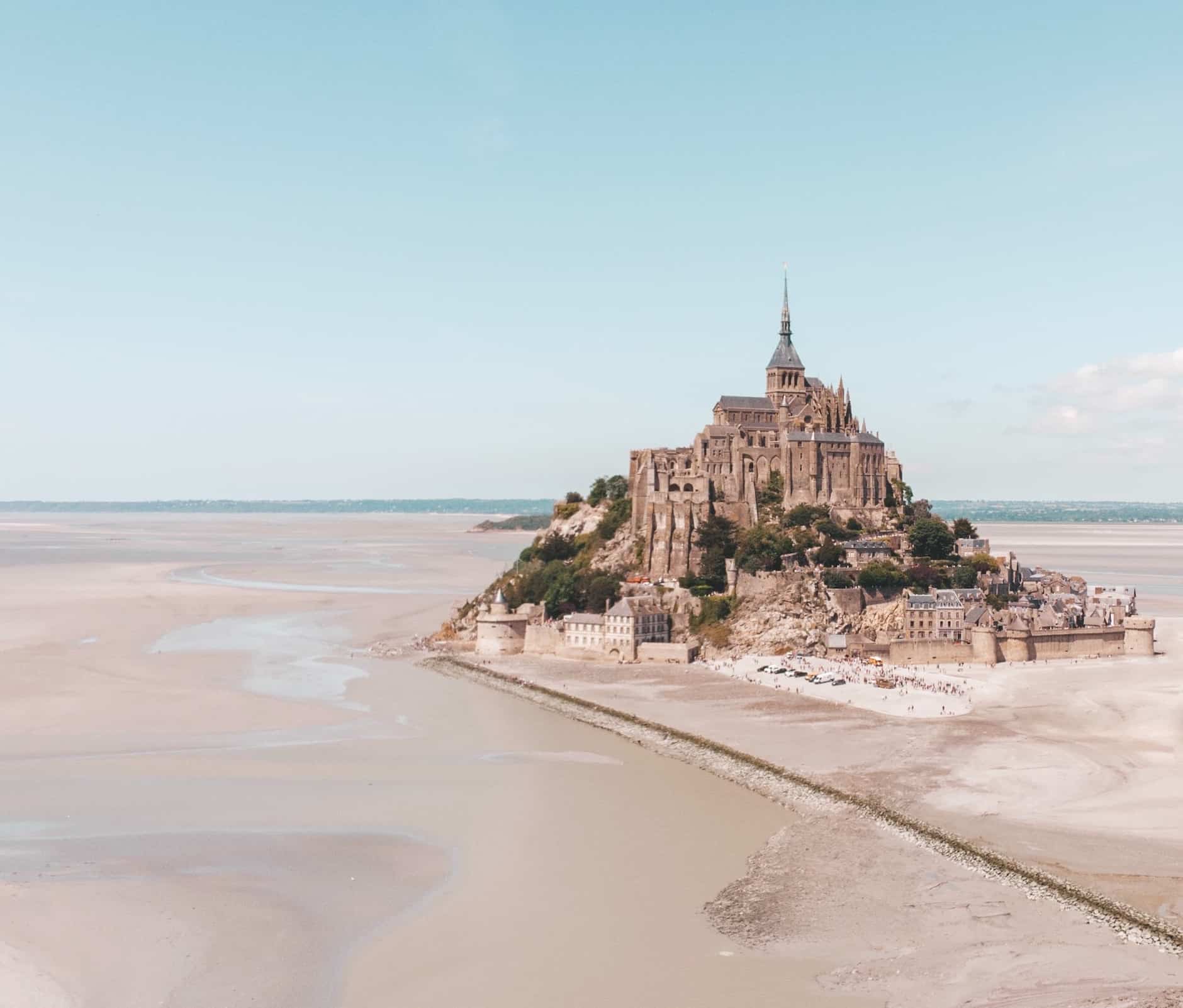 Mont-Saint-Michel vid lågvatten, med det majestätiska klostret som reser sig över sandbankarna i Normandie.