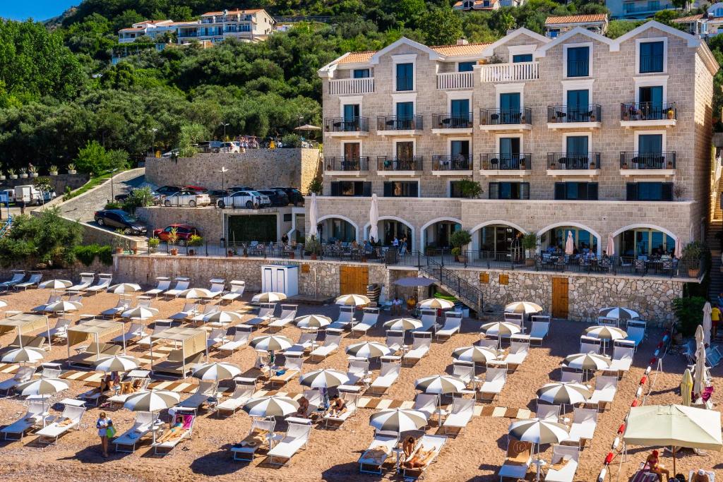 Hotel California by Aycon i bakgrunden, med hotellets restaurang och uteservering samt en vacker utsikt över stranden och Adriatiska kusten, Montenegro