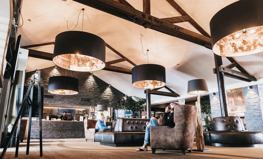 Hotel Riksgränsen-lobby -Kiruna Lappland, Fjällrestaurang i Riksgränsen med gäster och utsikt mot snöklädda berg.