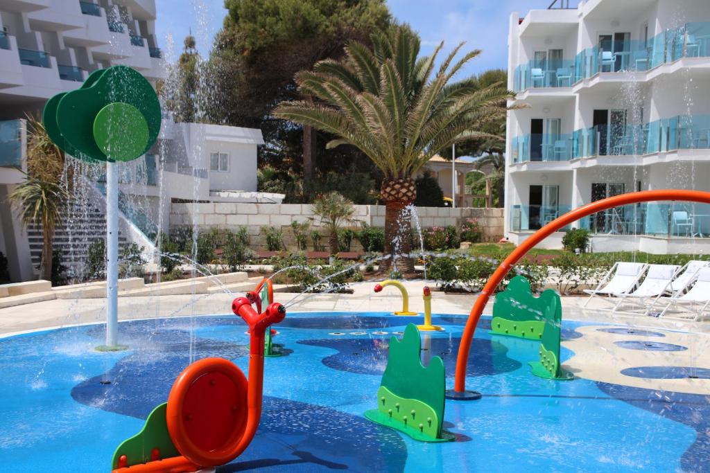 Barnvänligt poolområde med plaskzon på Iberostar Waves Playa de Muro på Mallorca, med färgglada vattenleksaker och lugn miljö – perfekt hotell för familjer som reser med små barn.