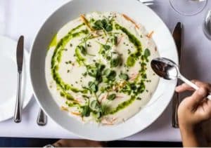 Elegant serverad gourmeträtt med krämig soppa och färska örter på Hankø Hotell & Spa