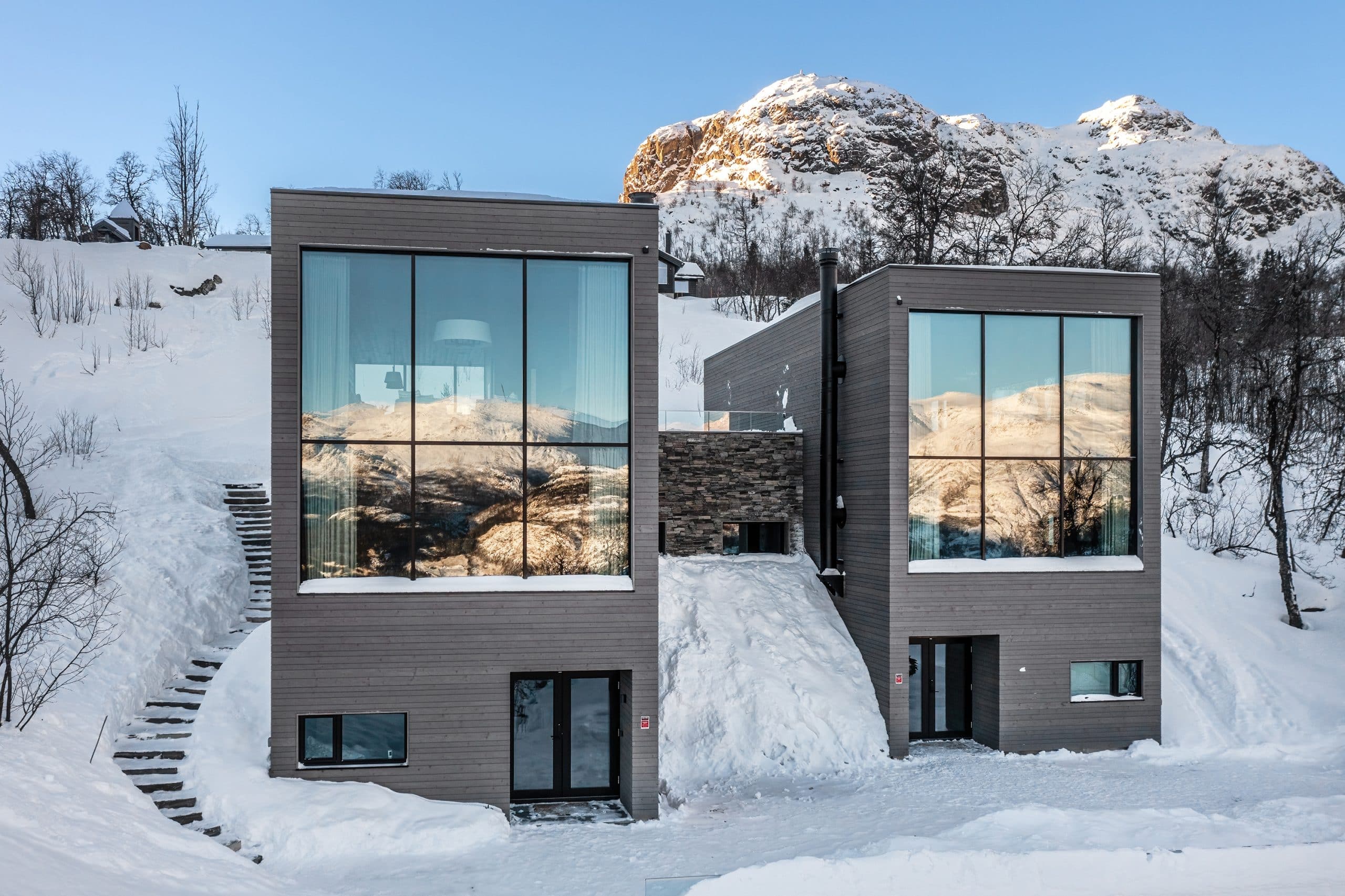 Exklusiva fjällstugor i Hemsedal med stora glasfönster och utsikt över snötäckta berg