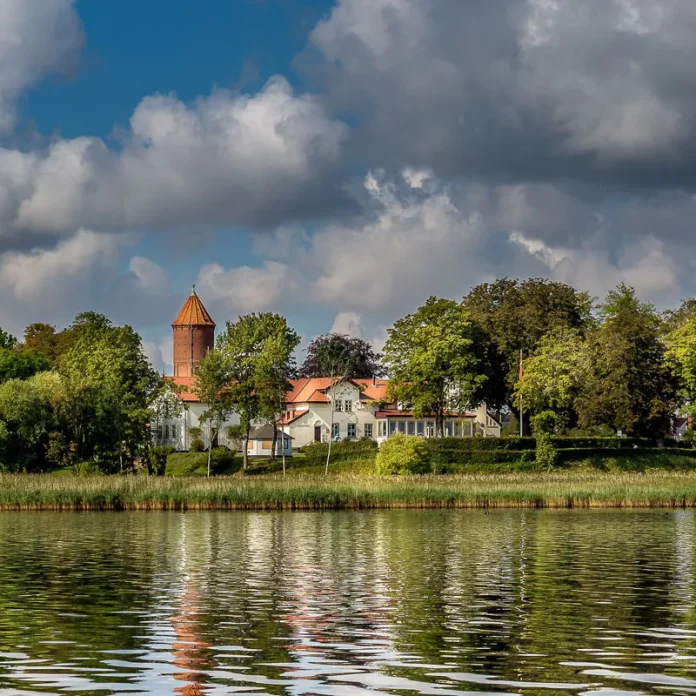 Frederiksminde restaurang och hotell i Præstø, Danmark, vackert beläget vid vattnet omgivet av natur och historiska byggnader.
