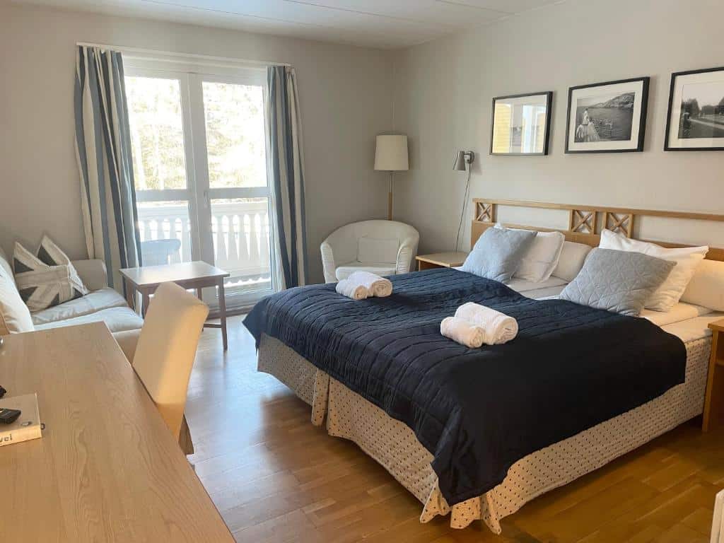 Ljust och rymligt hotellrum på Hankø med dubbelsäng, balkong och sittgrupp i skandinavisk stil