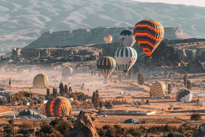 Luftballonger över Kappadokiens sagolika klippformationer i soluppgång