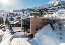 Modern lyxig fjällstuga i Hemsedal med stora fönster och utsikt över snötäckta fjäll och skidområde