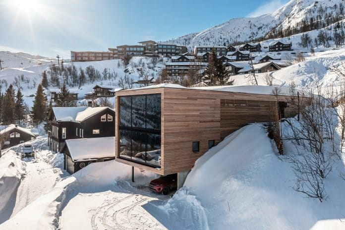 Modern lyxig fjällstuga i Hemsedal med stora fönster och utsikt över snötäckta fjäll och skidområde