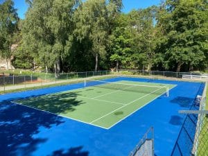 Tennisbana utomhus omgiven av grönska på Hankø Hotell & Spa